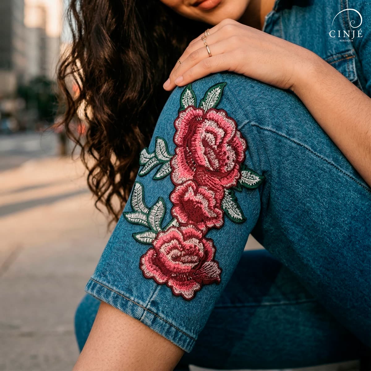 Modelo com bordado de rosas aplicado em jaqueta jeans